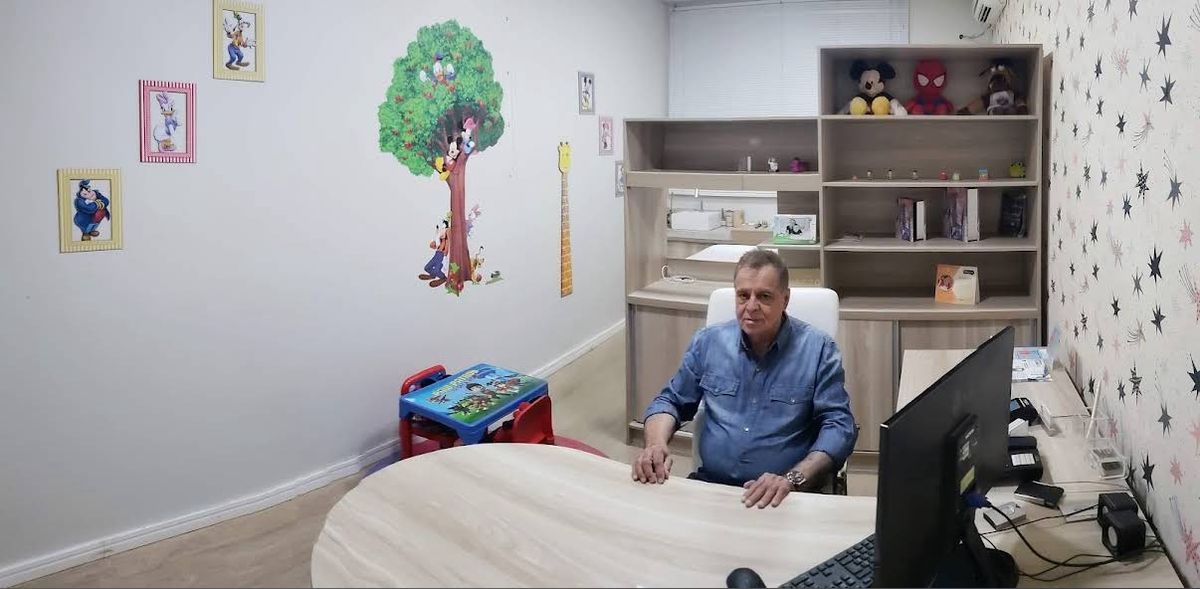 Sala de atendimento do consultório, com mesa e espaço para as crianças